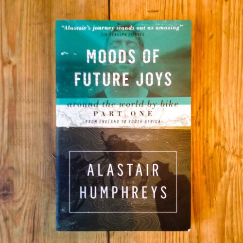 Books by Alastair Humphreys - Moods of Future Joys: Around the World by Bike – Part 1 - Cover on Wooden Floor