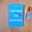 Books by Alastair Humphreys - A Notebook for Adventures: The Doorstep Mile - Cover on Wooden Floor