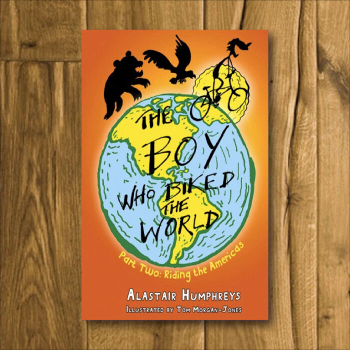 Books by Alastair Humphreys - The Boy Who Biked the World: Part Two: Riding the Americas - Cover on Wooden Floor